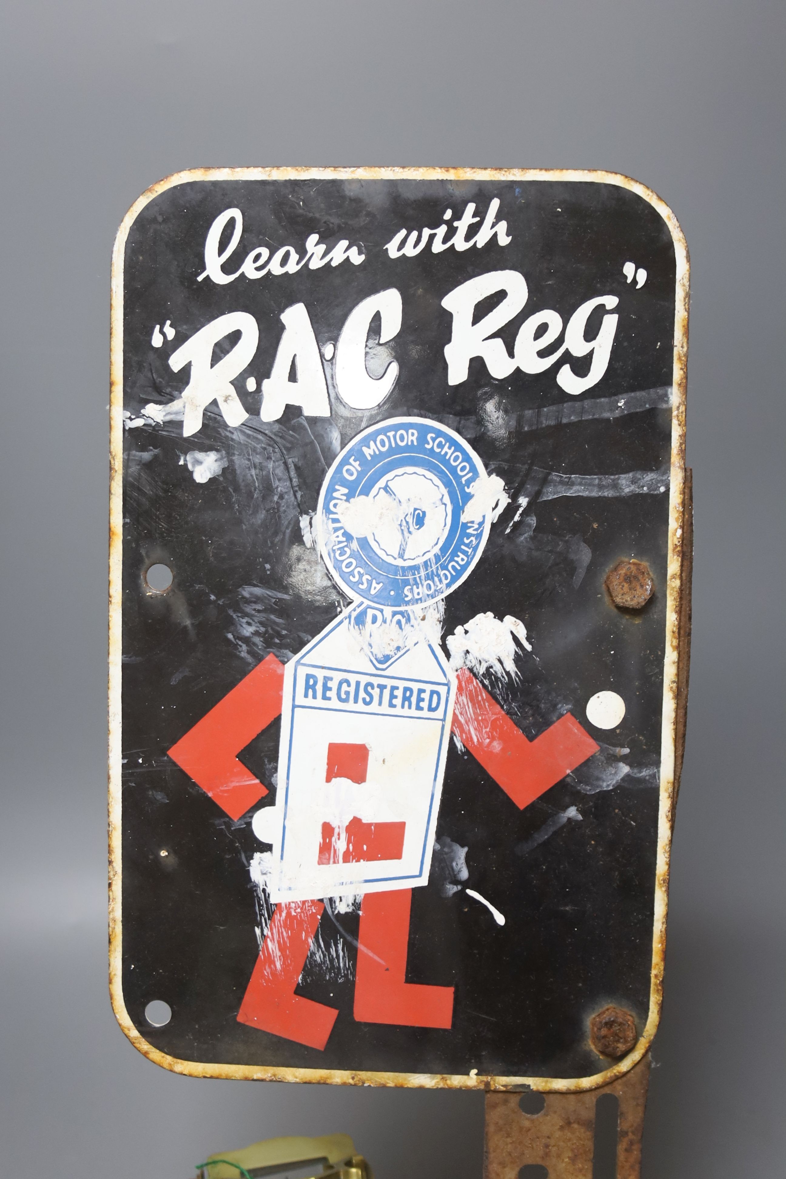An RAC Reg advertising enamel sign and a brass cased carriage timepiece